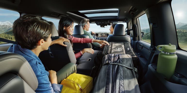 Family enjoying a road trip inside the spacious 2025 Nissan Armada with rear seating and ample cargo space