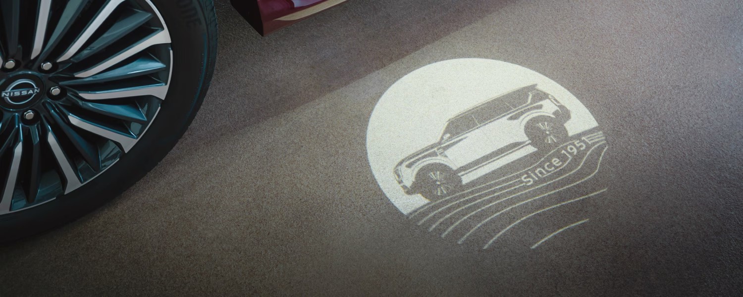 Projection light displaying a Nissan Armada silhouette with 'Since 195' on the ground